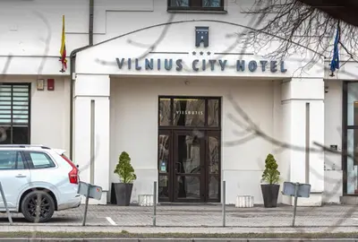 a white car parked in front of a building at Cosy Naujamiescio apartment in Vilnius