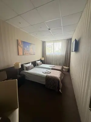 a hotel room with two beds and a window at Cosy Naujamiescio apartment in Vilnius