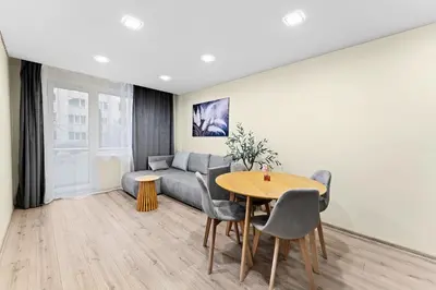 a living room with a table and a couch at Ramybes Oaze, Nauji stylingi apartamentai in Panevėžys