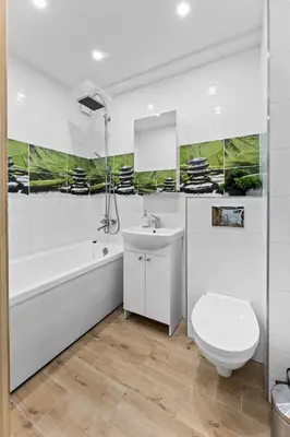 a white bathroom with a toilet and a sink at Ramybes Oaze, Nauji stylingi apartamentai in Panevėžys