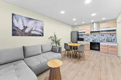 a living room with a couch and a table at Ramybes Oaze, Nauji stylingi apartamentai in Panevėžys