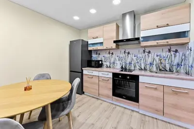a kitchen with a table and some glassases on the wall at Ramybes Oaze, Nauji stylingi apartamentai in Panevėžys