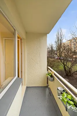 a balcony with two potted plants and a window at Ramybes Oaze, Nauji stylingi apartamentai in Panevėžys