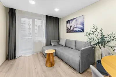 a living room with a couch and a table at Ramybes Oaze, Nauji stylingi apartamentai in Panevėžys