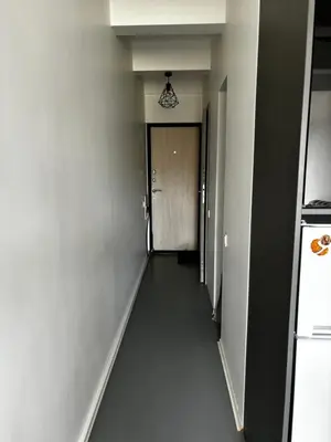 a hallway leading to a door in a building at Flat-studija in Vilnius