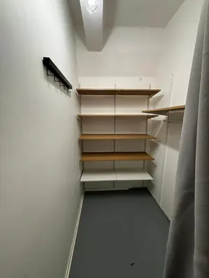 a closet with white shelves in a room at Flat-studija in Vilnius