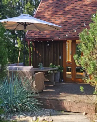 a patio with a table and an umbrella at Pond View Cabin in Būda