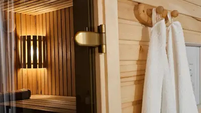 a bathroom with a shower with a white robe at Pond View Cabin in Būda
