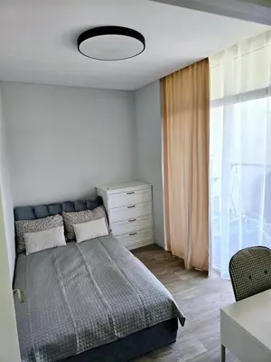 a bedroom with a bed and a dresser and a window at 3 rooms 3 beds apartment with garden in Kaunas