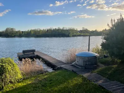 a dock with a bench on the side of a lake at Bijunai in Žaugėdai