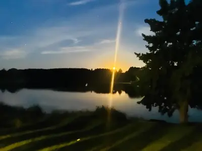 a sunset over a lake with the sun setting at Bijunai in Žaugėdai