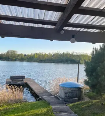 a wooden dock with a bench and a lake at Bijunai in Žaugėdai
