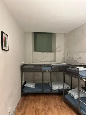a room with three bunk beds and a flat screen tv at Gate of Dawn by Kliefs Vilnius - Virtual Check-In in Vilnius