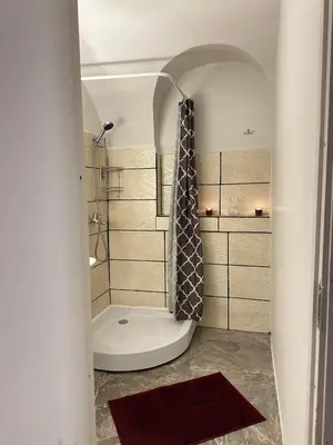 a bathroom with a shower with a shower curtain at Gate of Dawn by Kliefs Vilnius - Virtual Check-In in Vilnius