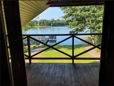 a view of a lake from the porch of a house at Atostogų namelis ant ežero kranto in Juočionys