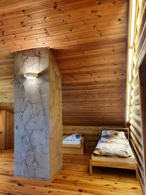 a room with two beds in a log cabin at Atostogų namelis ant ežero kranto in Juočionys