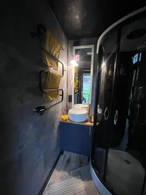 a bathroom with a van with a sink and a mirror at Vilnius river house in Dusinėnai