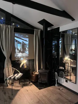 a living room with a fireplace and a tv at Vilnius river house in Dusinėnai