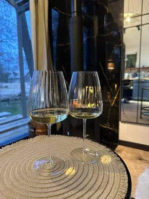two glasses of white wine sitting on a table at Vilnius river house in Dusinėnai