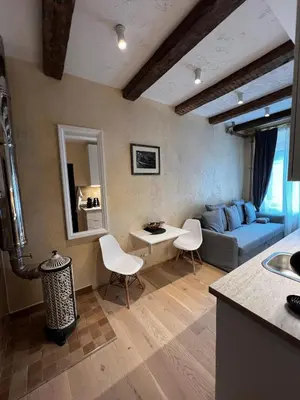 a living room with a blue couch and white chairs at BONUM apartments in Vilnius old town in Vilnius