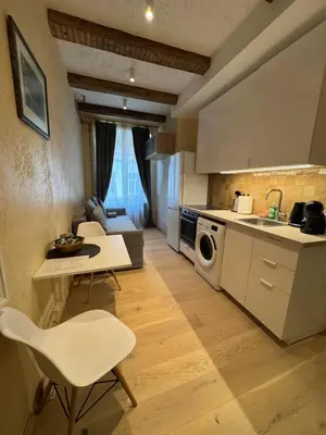 a kitchen with a table and a sink and a microwave at BONUM apartments in Vilnius old town in Vilnius
