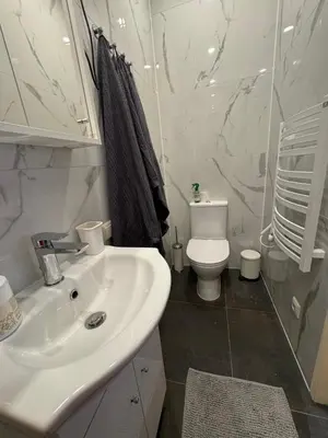 a white bathroom with a sink and a toilet at BONUM apartments in Vilnius old town in Vilnius
