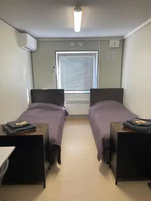 a room with two beds and a window at Pabrades Apartamentai in Pabradė