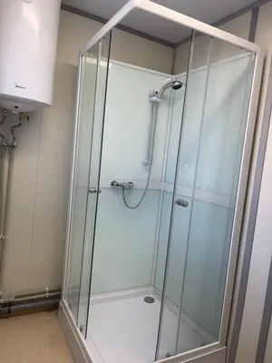 a shower with a glass enclosure in a bathroom at Pabrades Apartamentai in Pabradė