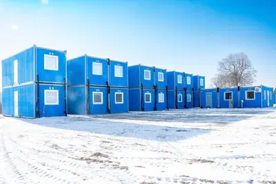 a row of blue buildings in the snow at Pabrades Apartamentai in Pabradė