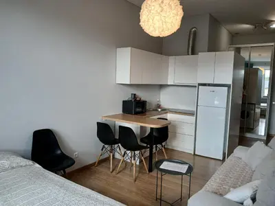 a kitchen with a table and chairs in a room at Studija Kauno centre in Kaunas