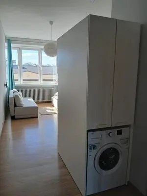 a kitchen with a washing machine in a room at Studija Kauno centre in Kaunas