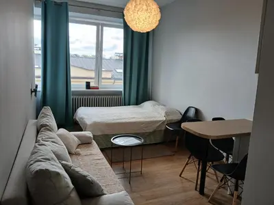 a room with two beds and a couch and a table at Studija Kauno centre in Kaunas