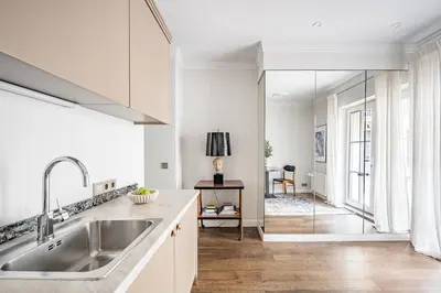 a kitchen with a sink and a glass shower door at Super Central Studio in Vilnius