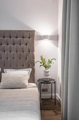 a bedroom with a bed and a vase with a plant on a table at Super Central Studio in Vilnius