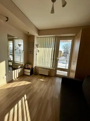 an empty living room with wooden floors and large windows at Sunny Lotus Apartamentai in Druskininkai