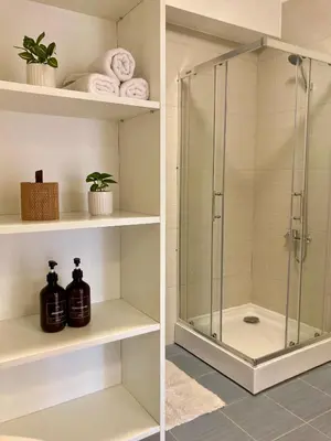 a bathroom with a shower with glass doors at Sunny Lotus Apartamentai in Druskininkai