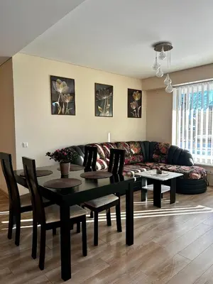a living room with a black table and a couch at Sunny Lotus Apartamentai in Druskininkai