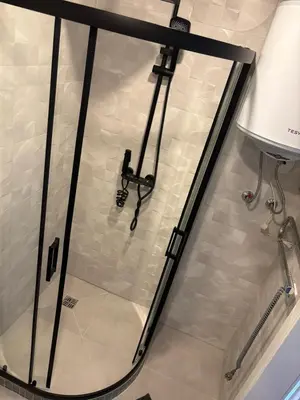 a glass shower door in a bathroom with a lamp at RR Apartments in Algirdo street in Vilnius