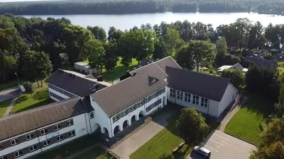 an aerial view of a large white building next to a lake at Linkmenų sporto ir rekreacijos centras in Linkmenys