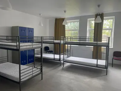a room with three bunk beds and two chairs at Linkmenų sporto ir rekreacijos centras in Linkmenys