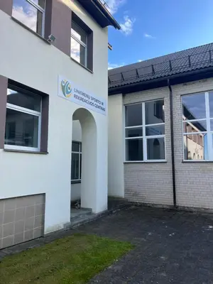 an entrance to a building with a sign on it at Linkmenų sporto ir rekreacijos centras in Linkmenys