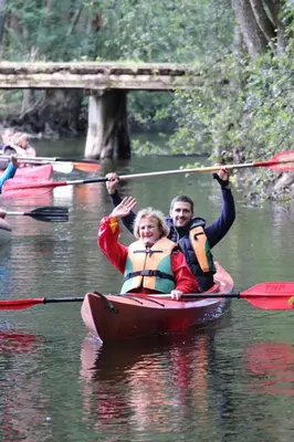 a man and woman in a kayak on a river at Linkmenų sporto ir rekreacijos centras in Linkmenys