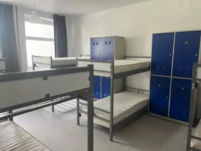 a room with two bunk beds and blue cabinets at Linkmenų sporto ir rekreacijos centras in Linkmenys