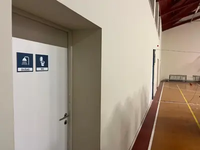 an empty hallway with a tennis court in a building at Linkmenų sporto ir rekreacijos centras in Linkmenys