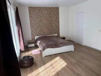 a bedroom with a bed and a wooden floor at Saulutė in Birštonas