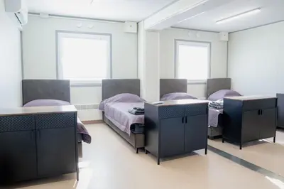 a bedroom with two beds and two desks at Pabrades Apartamentai in Pabradė