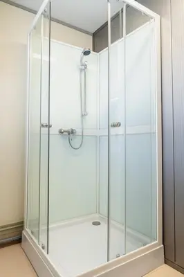a shower with a glass enclosure in a bathroom at Pabrades Apartamentai in Pabradė