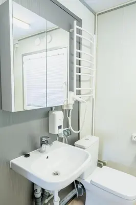 a bathroom with a sink and a toilet and a mirror at Pabrades Apartamentai in Pabradė