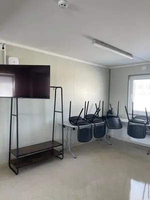 a room with four chairs and a table with a flat screen tv at Pabrades Apartamentai in Pabradė