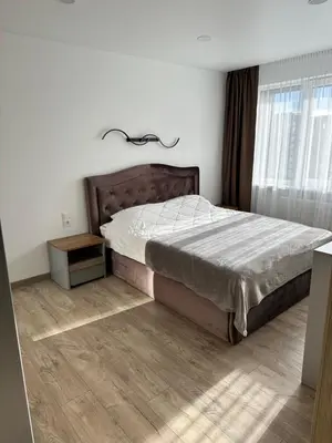 a bedroom with a bed and a wooden floor at Lauros Apartamentai in Kupiškis